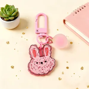 Detailed view of pink acrylic rabbit keychain with hand-drawn texture and round charm