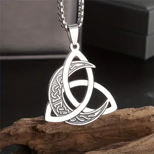 Macro detail view of a vintage Viking Triquetra crescent moon pendant in stainless steel