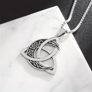 Detailed macro view of a vintage stainless steel Viking Triquetra moon phase pendant