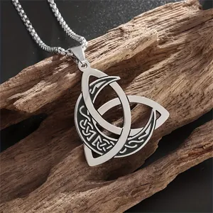 Close-up of Viking triquetra knot pendant with moon phase on rustic wood background
