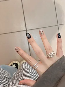 Detailed close-up of stylish press-on nails with cute heart and cartoon dog designs