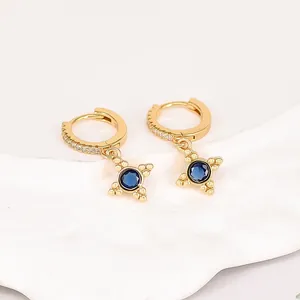 Detail of gold hoop earrings with blue zircon cross charms and S925 silver needle