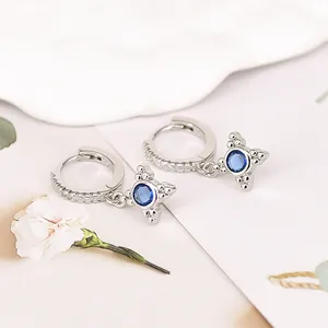 Detailed macro shot of elegant S925 silver hoop earrings featuring blue zircon star charms