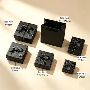 Set of black jewelry gift boxes with satin ribbons and tote bags in various sizes