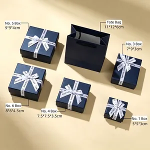 Comparison of various sizes of navy blue jewelry gift boxes with bow ribbons.