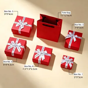 Red jewelry gift box set with white ribbons in various sizes and matching bag