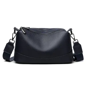Elegant navy blue genuine leather crossbody bag with pebbled texture and wide strap