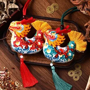 Close-up of traditional embroidered dragon sachet pendants with long silk tassels