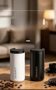 Pair of black and white portable insulated coffee tumblers on a wooden table