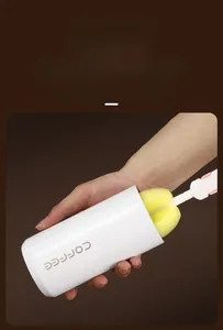 Macro view of wide mouth coffee tumbler being cleaned with a yellow sponge brush