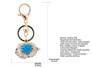 Detailed dimensions of a golden pig keychain charm decorated with blue heart rhinestones