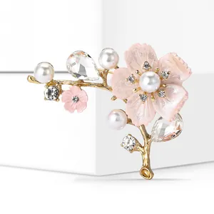 Close-up of pink cherry blossom brooch with elegant pearls and sparkling crystals