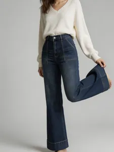 Detail view of women's high-waisted wide-leg jeans with washed finish and cuffed hems
