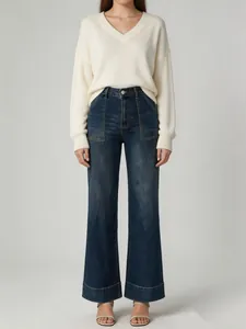 Detail of women's high waisted wide leg jeans with washed blue finish and front pockets