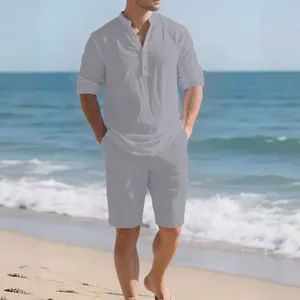 Man in light grey linen long sleeve shirt and matching shorts on a sunny beach