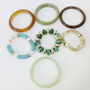 Detail view showing assorted vintage resin bangles and green marble beaded bracelets.