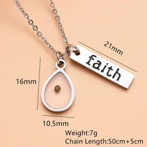 Close-up detail of stainless steel necklace with faith bar and mustard seed pendant