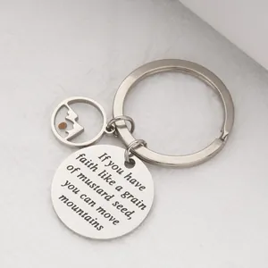 Detailed view of a stainless steel mustard seed faith keychain with engraved quote