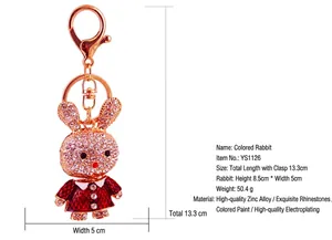 Detailed size measurements of a rhinestone rabbit keychain with red enamel dress.