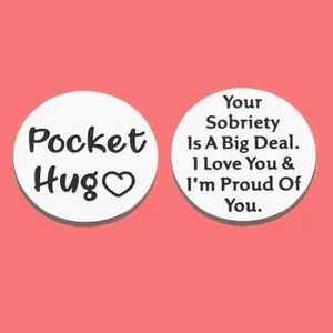 Stainless steel pocket hug token with sobriety encouragement text on pink background.