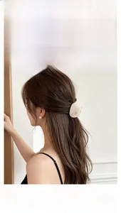 Side view of woman wearing a cute cat-shaped hair claw clip on long brunette hair