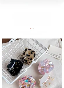 Close-up detail showing various cute cat-shaped acetate hair clips in marble colors