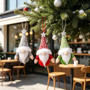 Three colorful Christmas gnome plush ornaments hanging on a festive pine tree