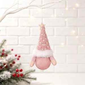 Close-up of pink plush Christmas gnome ornament hanging from a white decorative branch