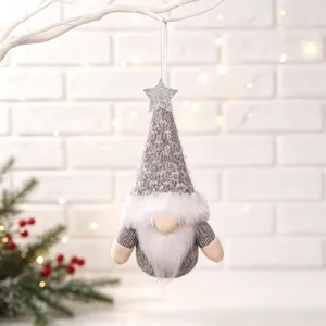Detailed view of a handmade grey Christmas gnome ornament hanging on a snowy branch