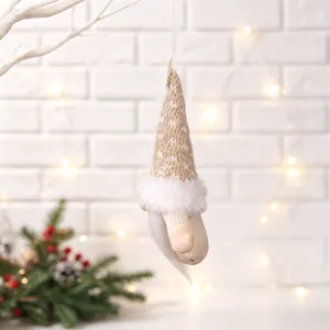 Handmade Christmas gnome fabric hanging ornament decoration on white brick background