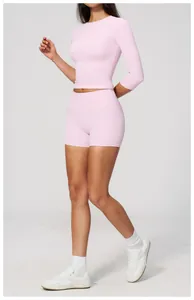 Vista intera di una modella in un set da yoga rosa chiaro con pantaloncini e top.