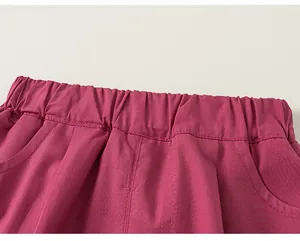 Close-up detail of pink children's shorts with elastic waistband and side pockets