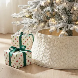 Close-up of a white cable-knit Christmas tree collar surrounding a snowy tree base