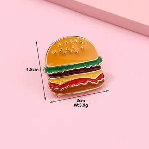 Detailed view of enamel burger brooch showing 1.8cm x 2cm size and 5.9g weight specs