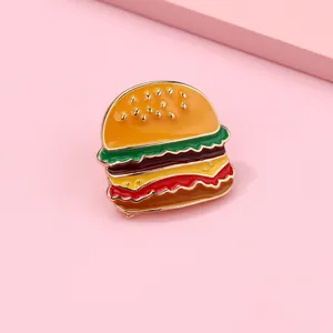 Detailed view of an enamel hamburger brooch with colorful layers and golden sesame accents