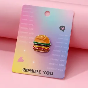 Detailed close-up of a burger enamel pin on a decorative backing card for styling