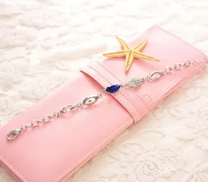 Détail du bracelet en chaîne argentée avec cristaux bleu marine et accents pavés