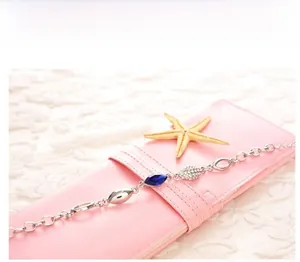Detail of silver chain bracelet featuring navy marquise crystals and pavé accents