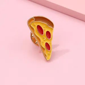 Macro detail of pizza enamel pin with golden metal edge and colorful toppings