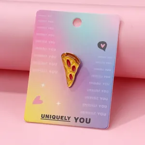 Detail of creative pizza enamel pin with golden outlines on a colorful display card
