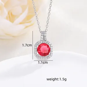 Macro shot of 1.7cm red zircon necklace pendant with silver chain and white floral background