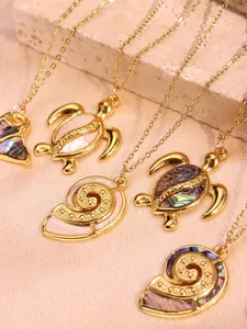 Macro detail of gold stainless steel necklaces with abalone shell sea life pendants
