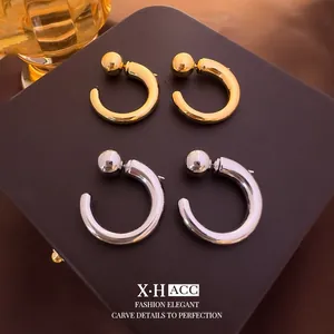 Minimalist geometric C-shaped stud earrings in gold and silver with a polished finish