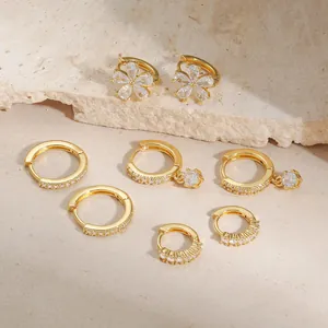Elegant gold flower earring set with sparkling cubic zirconia on natural stone background