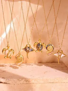 Detail of marine pendants featuring sea turtle and manta ray in gold with shell inlay