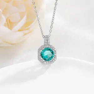 Detail shot of an octagon halo necklace with a round green gemstone and zircon accents