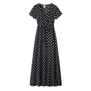 Detail of V-neck black polka dot dress featuring short sleeves and a waist tie-up bow