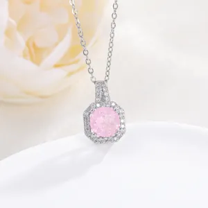 Macro shot of hexagonal silver necklace with pink stone and zircon halo on white stand