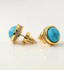 Macro detail of round blue turquoise earrings with zircon pavé set in golden finish