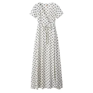 Detailed view of white polka dot wrap dress with V-neckline and waist tie detail